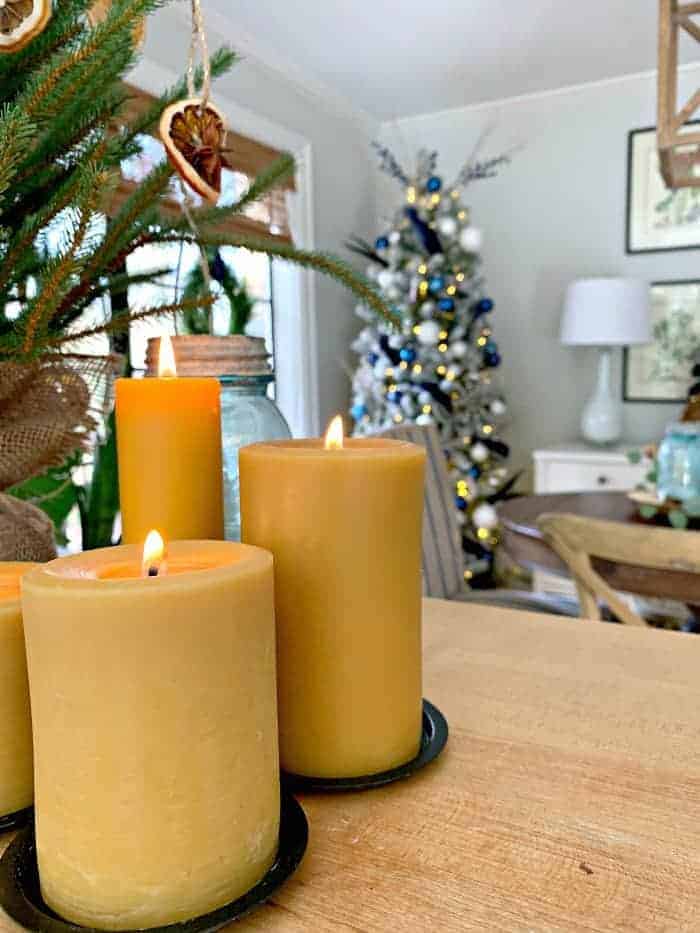 grouping of beeswax candles on kitchen island with navy Christmas tree in the background