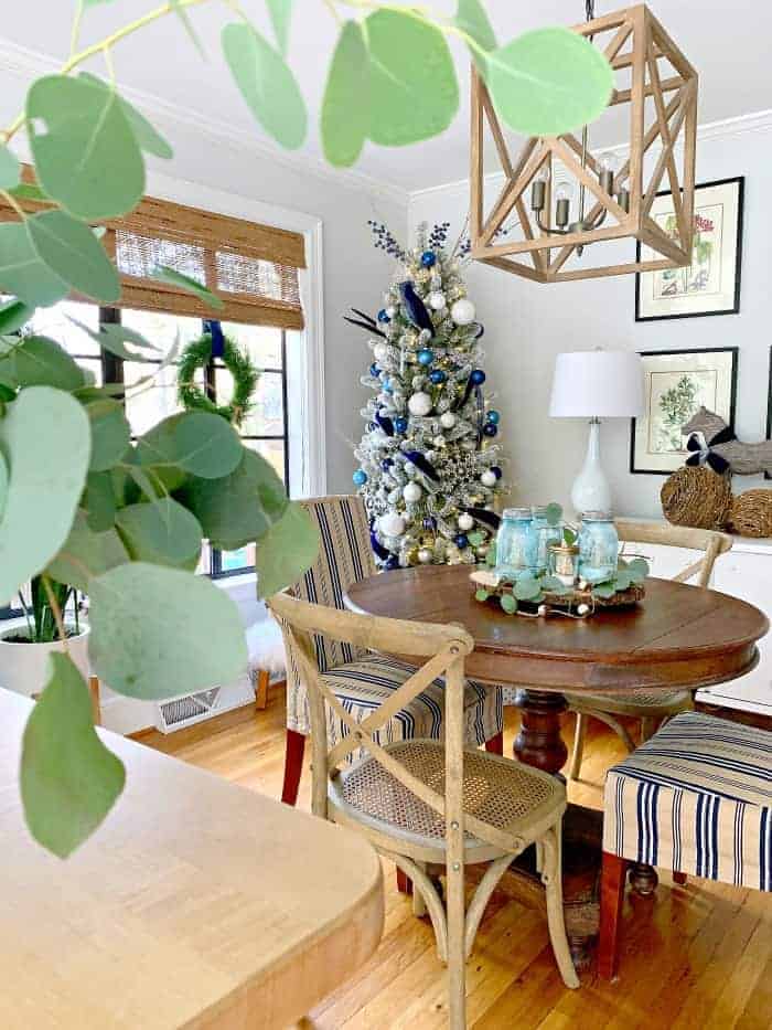 Navy blue Christmas decor and Christmas tree in dining room with round wood table