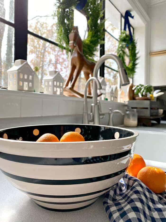 oranges in black and white stripe bowl on kitchen counter