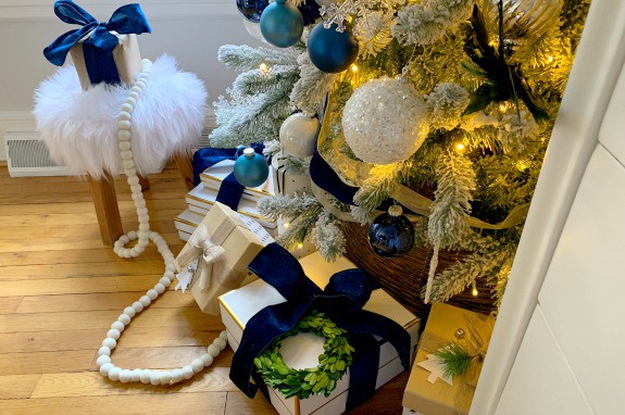 Christmas presents wrapped in velvet ribbon under flocked Christmas tree
