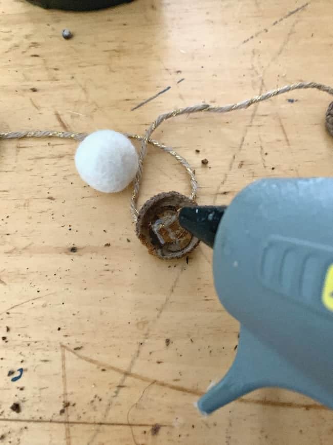applying hot glue to acorn top