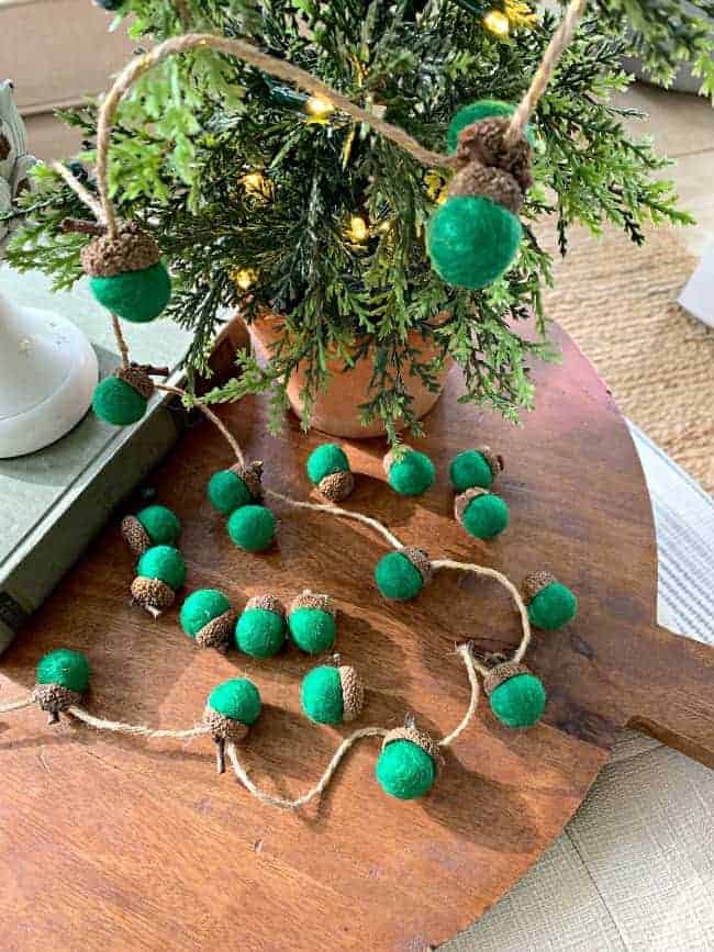 overview of felted green acorn garland on cutting board