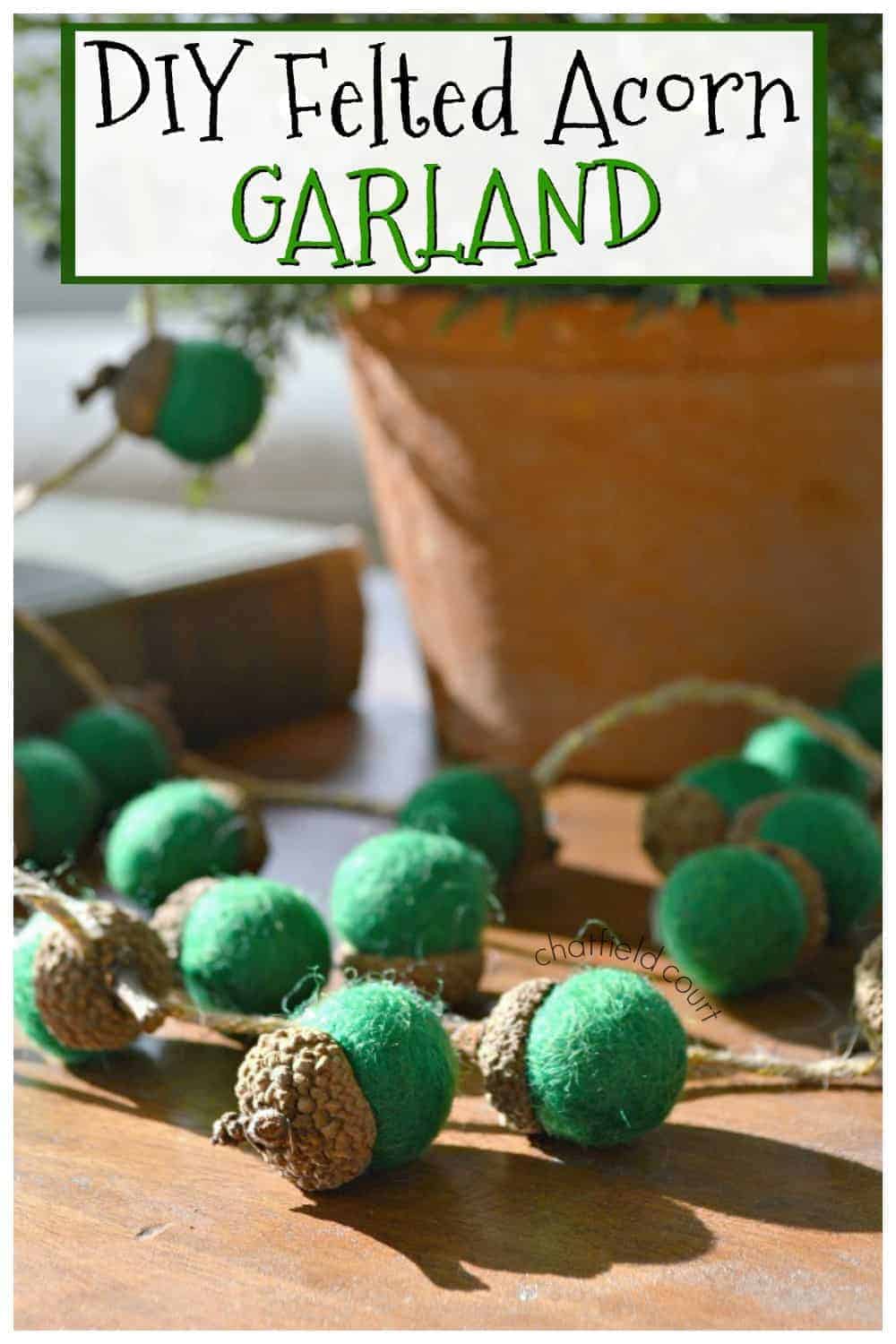 felted green acorn garland on cutting board with large graphic