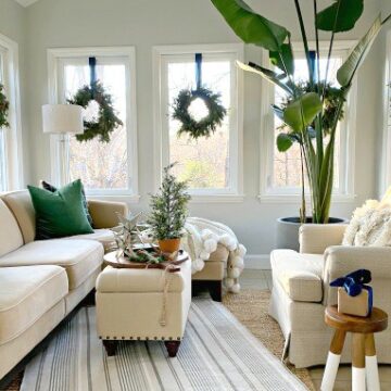 view of sunroom decorated for the holidays with wreaths hanging on the windows