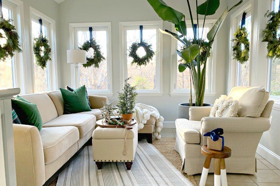 view of sunroom decorated for the holidays with wreaths hanging on the windows