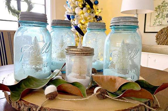DIY mason jar Christmas centerpiece on dining table with tree in background