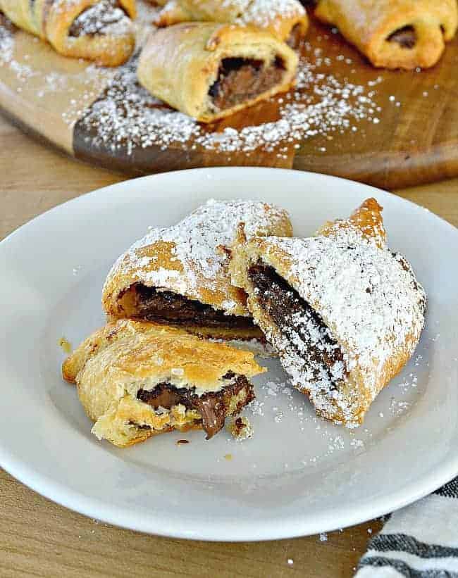 sliced nutella crescent rolls with powdered sugar on white plate 