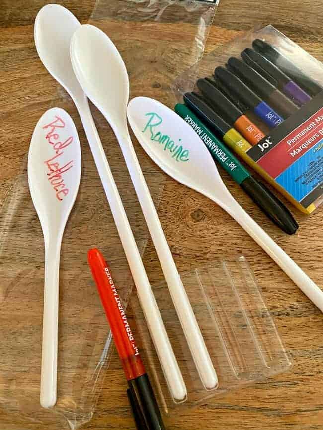 white plastic spoons and pack of markers on cutting board