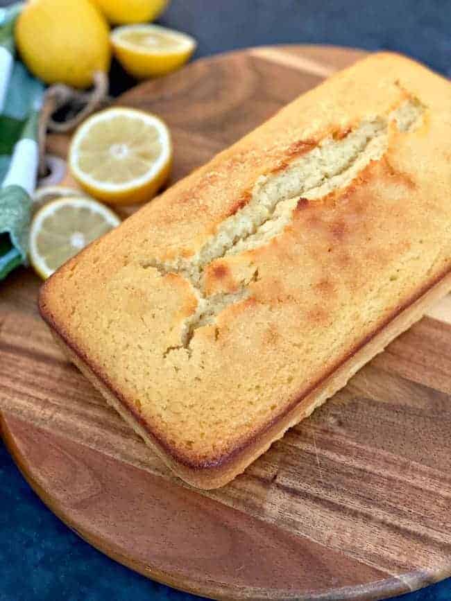 fresh baked lemon loaf on round wood cutting board