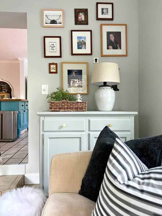 picture gallery wall with a painted chest in a small sunroom