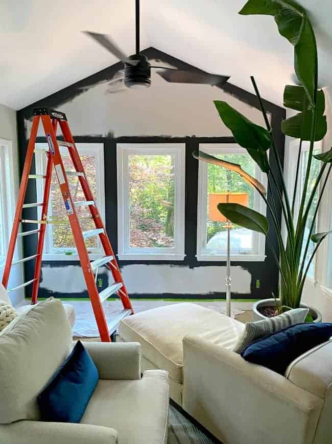 painting an accent wall dark gray in a sunroom with 3 windows looking outside