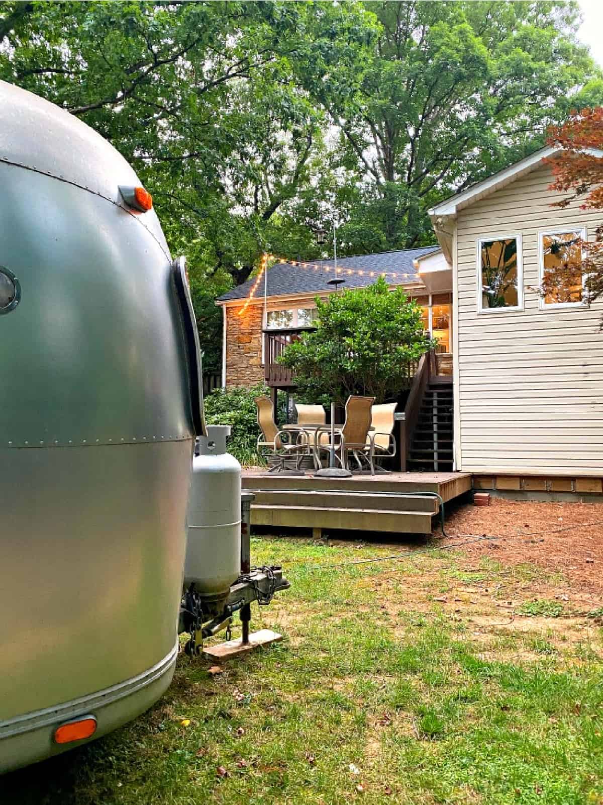 side view of Airstream and back deck with string lights
