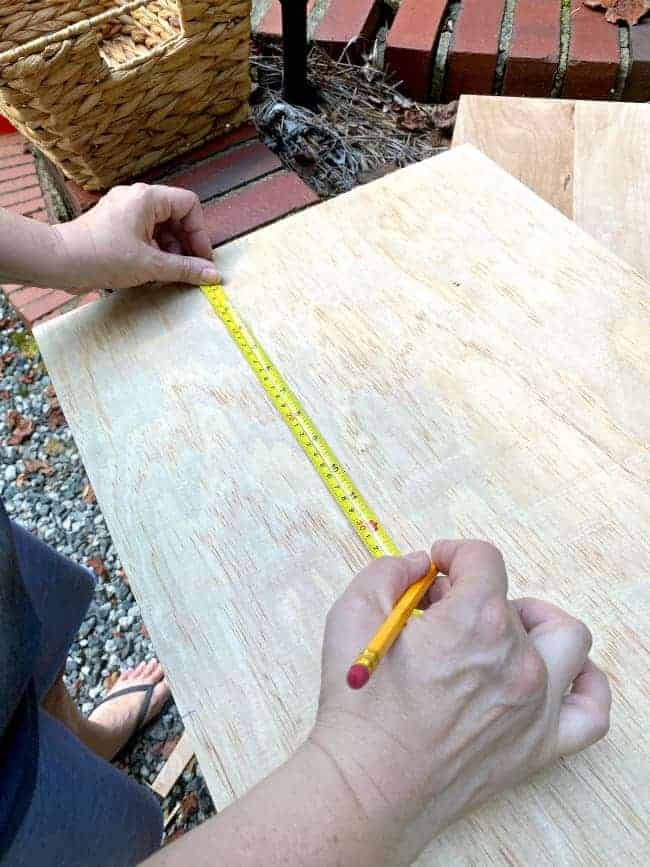 marking measurements on underlayment with tape measure and pencil