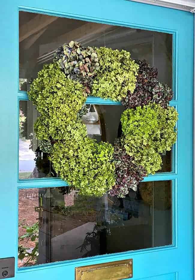 dried hydrangea wreath hanging on a turquoise door