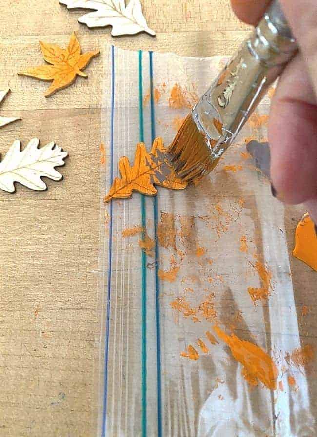 painting wooden craft leaves with orange paint