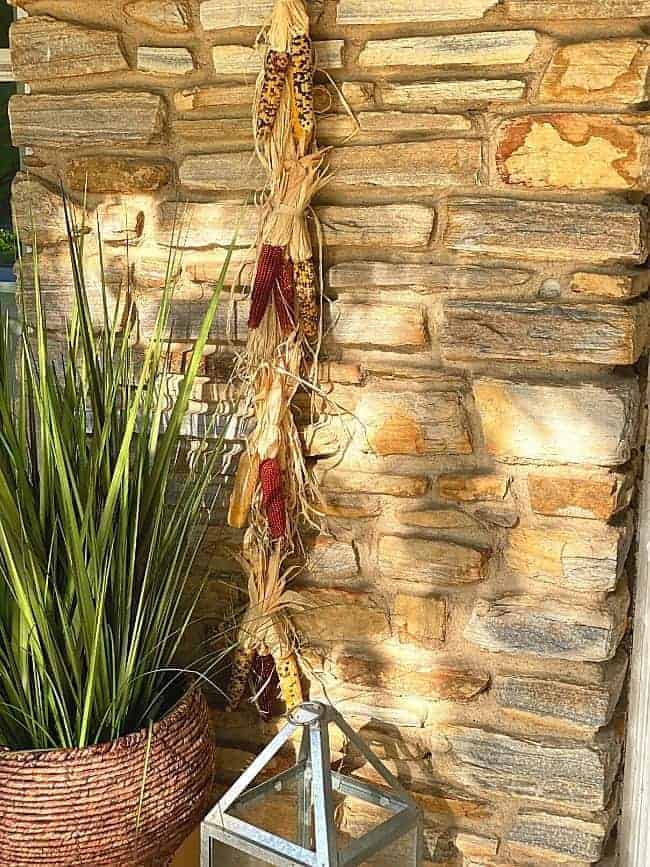 mini Indian corn and raffia hanger on stone wall