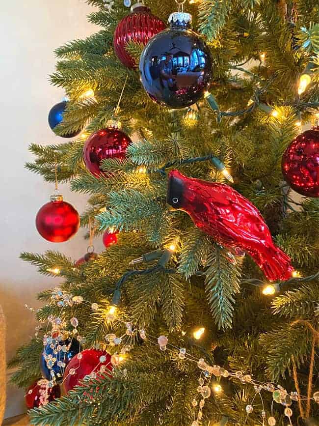 red and navy ornaments and a red cardinal ornament on a Christmas tree