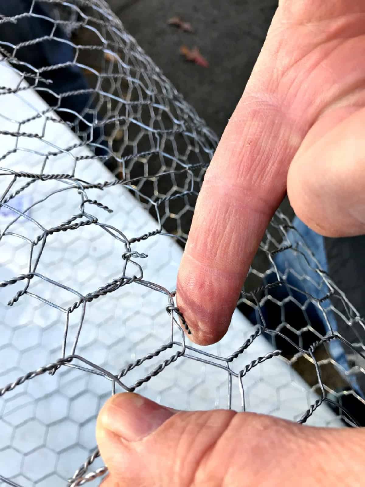 How to Make Lighted Christmas Balls (And How to Hang Them) pix bending tabs in cut chicken wire to make DIY lighted chicken wire Christmas balls