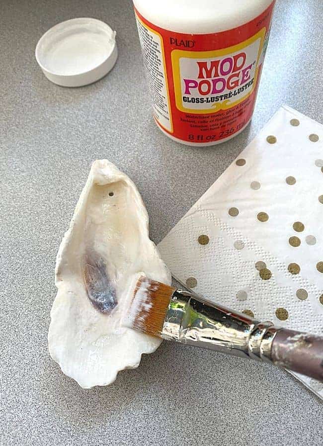 brushing Mod Podge on seashell