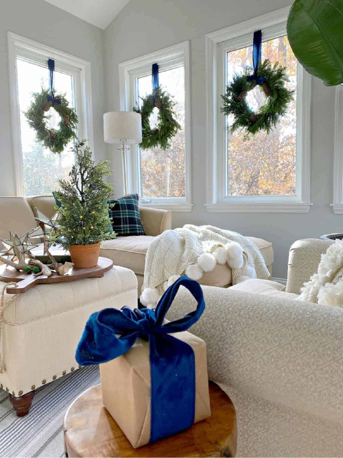 Christmas wreaths hanging in windows with blue velvet ribbon