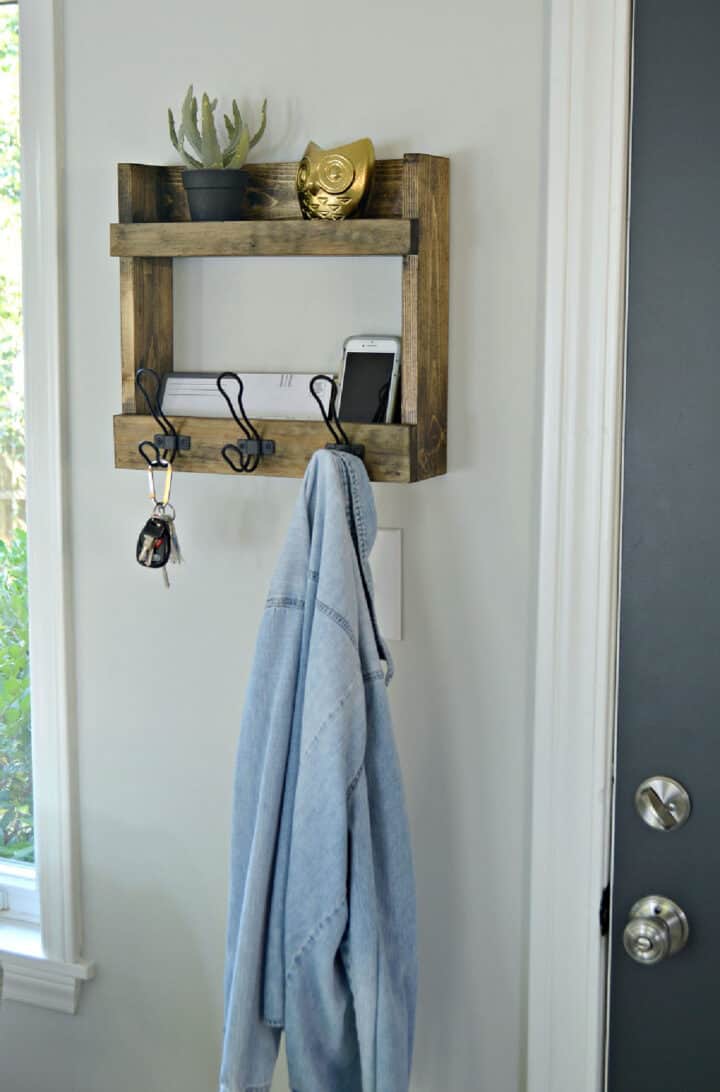 DIY coat rack with shelves hanging on wall next to door