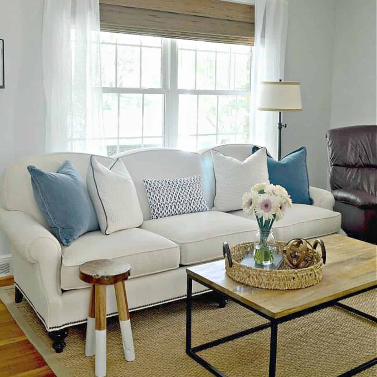 new white sofa in living room with blue and white pillows
