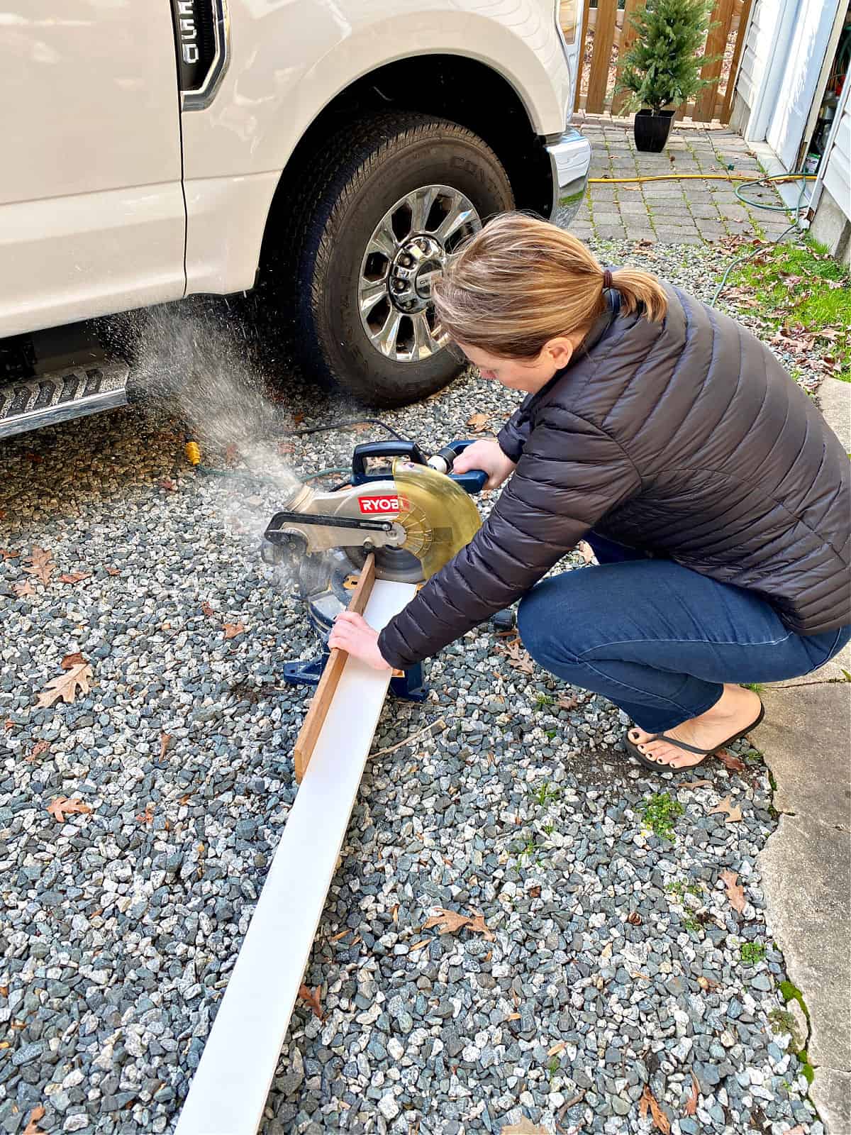 woman cutting wood on miter saw