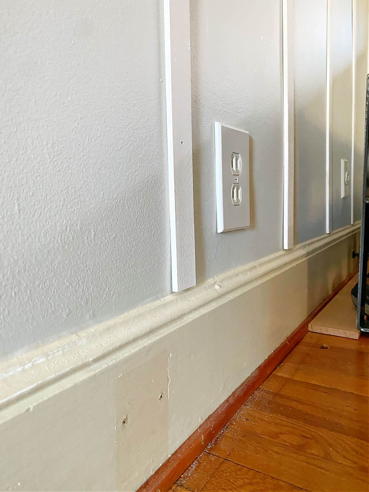 white wood battens resting on wall trim