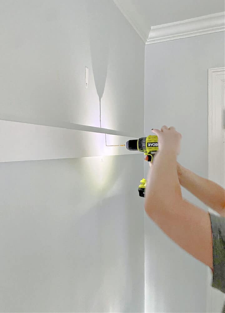 Easy Board and Batten Accent Wall photo screwing in DIY board and batten with a drill