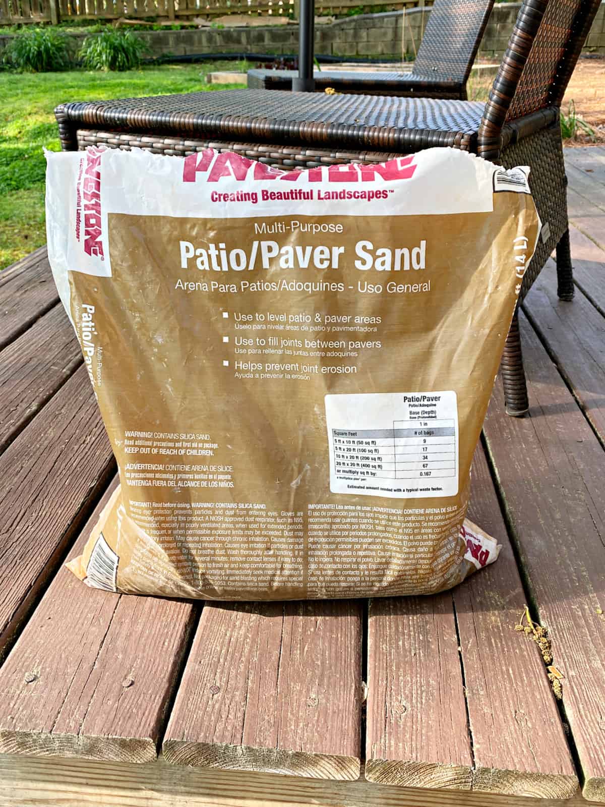 How to Lay Brick Edging In Your Garden picture bag of paver sand sitting on backyard deck