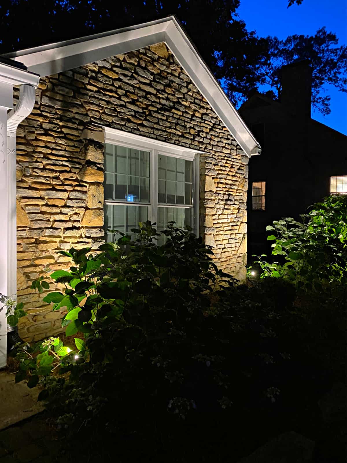 front of stone cottage with outdoor spot lights