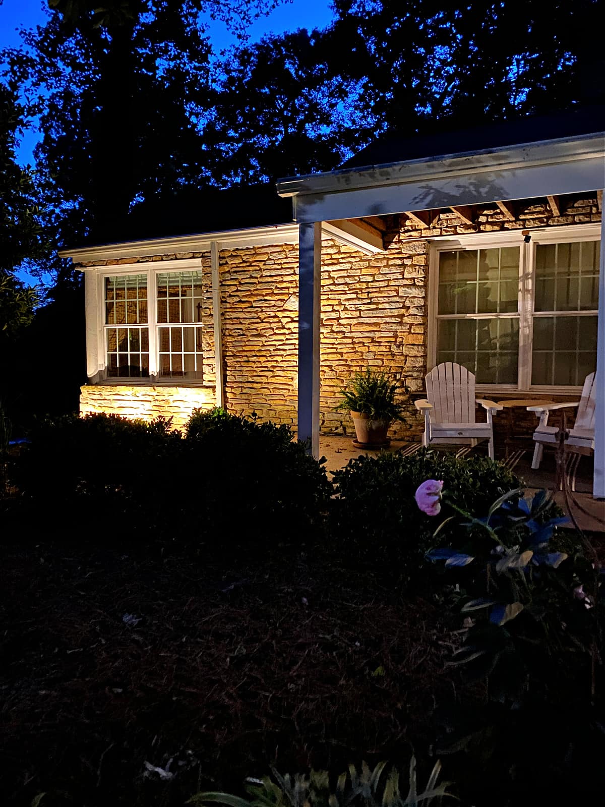 front of stone cottage with outdoor spot lights