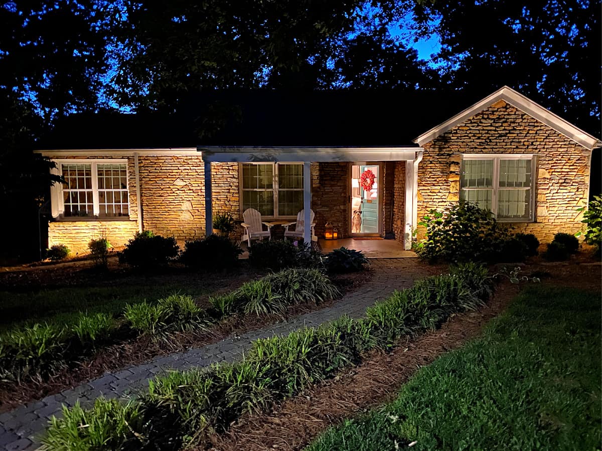 front of stone cottage with outdoor spot lights