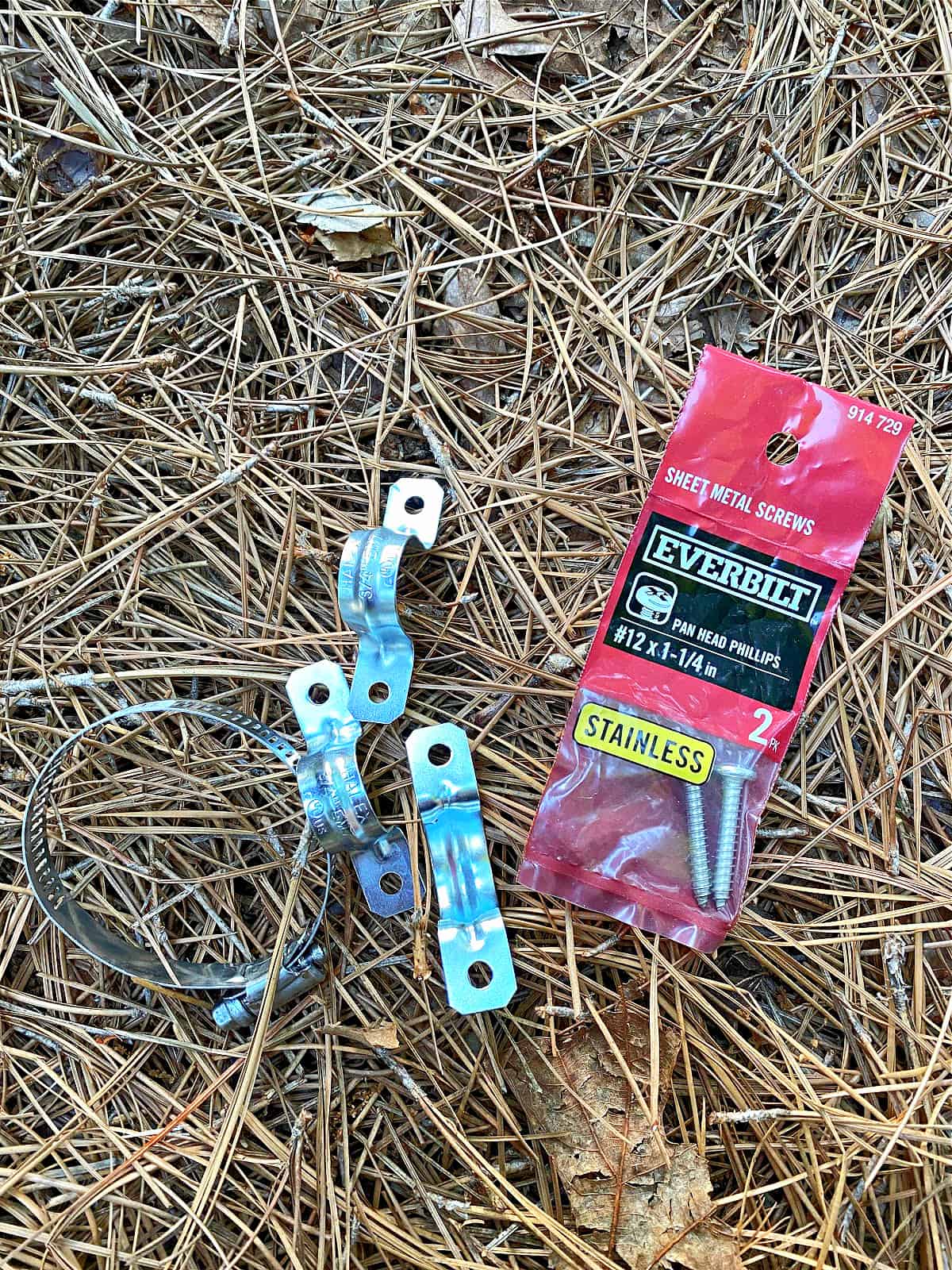 pack of screws and hole straps on ground