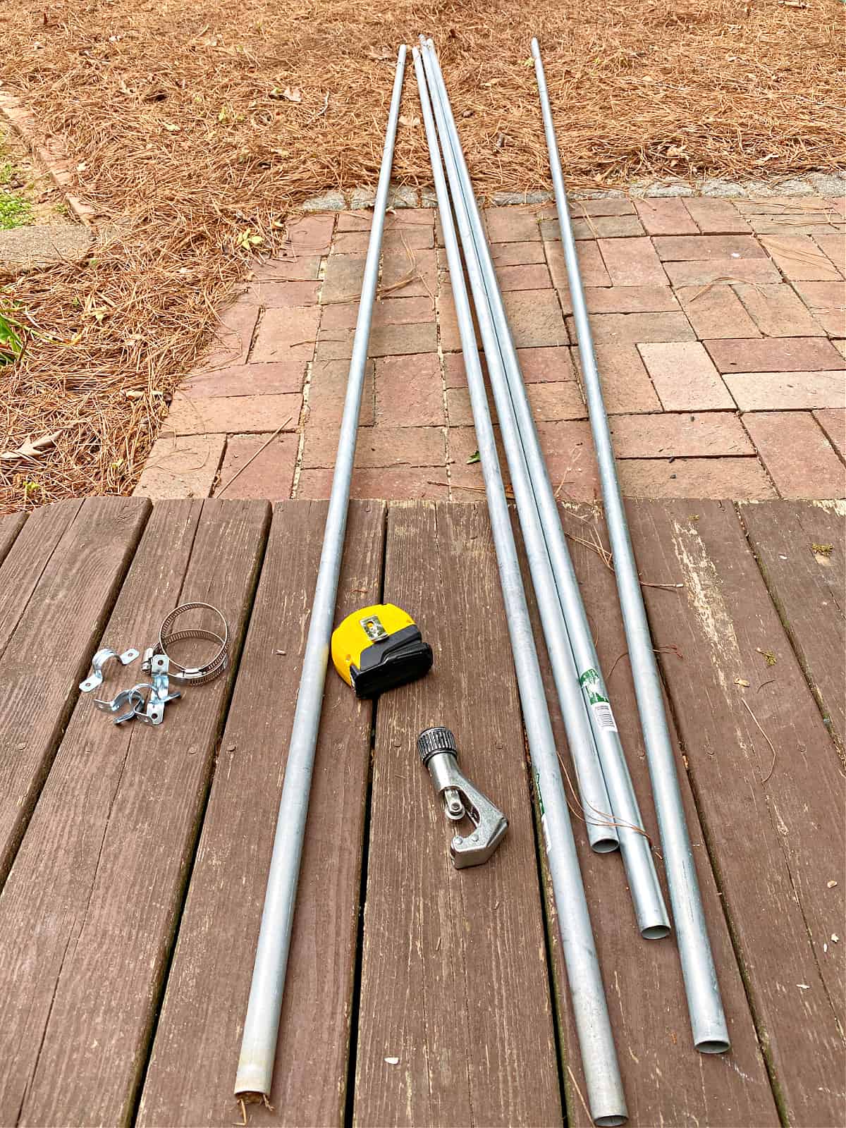 conduit pipe, tape measure, pipe cutter on ground