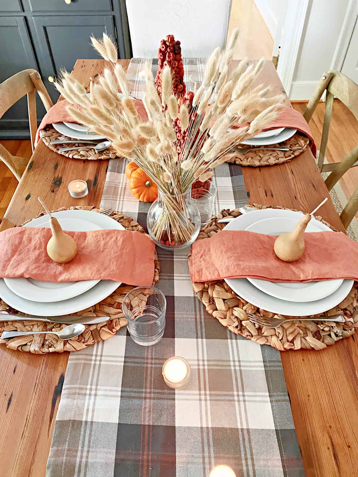 table set for fall with a table runner and white dishes with napkins