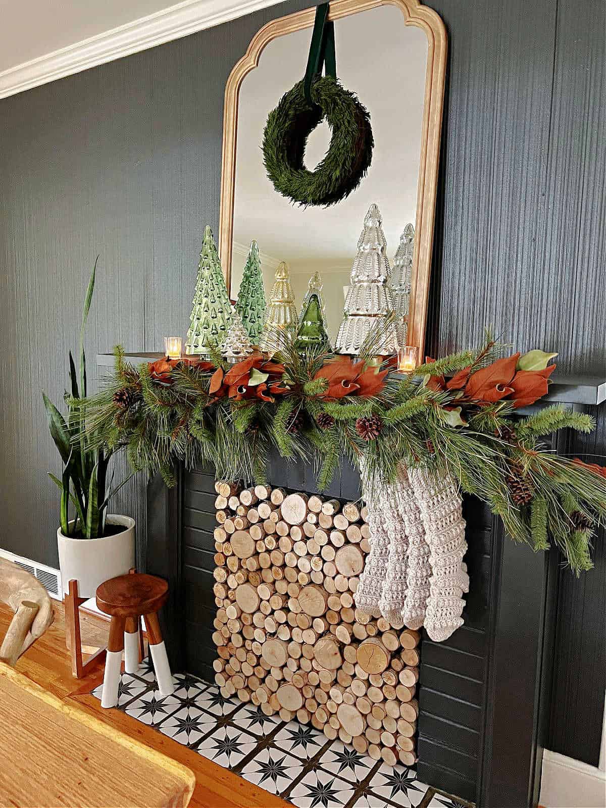 fireplace decorated for Christmas with garland, stockings and a wreath