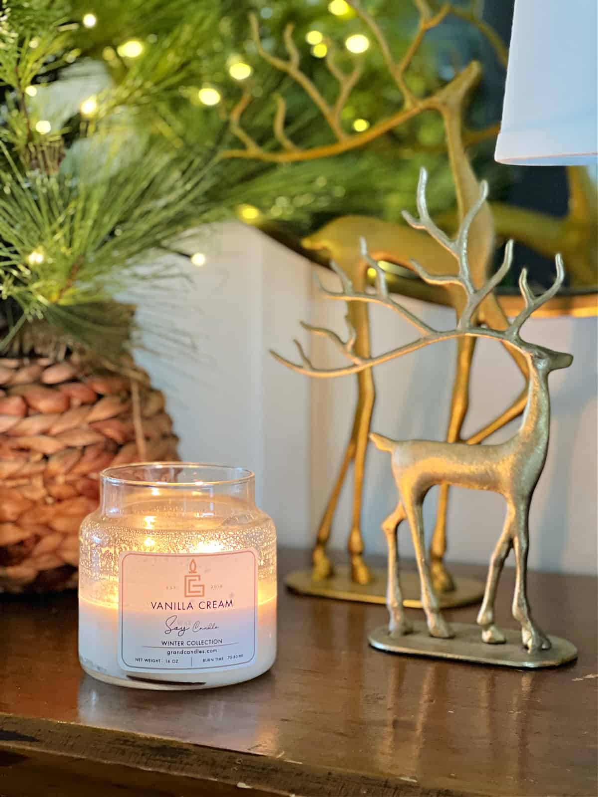 lighted candle and brass colored reindeer on console