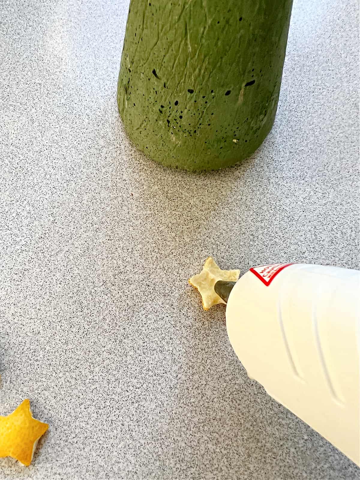 How to Make a Concrete Christmas Tree glue img adding hot glue on small lemon peel star