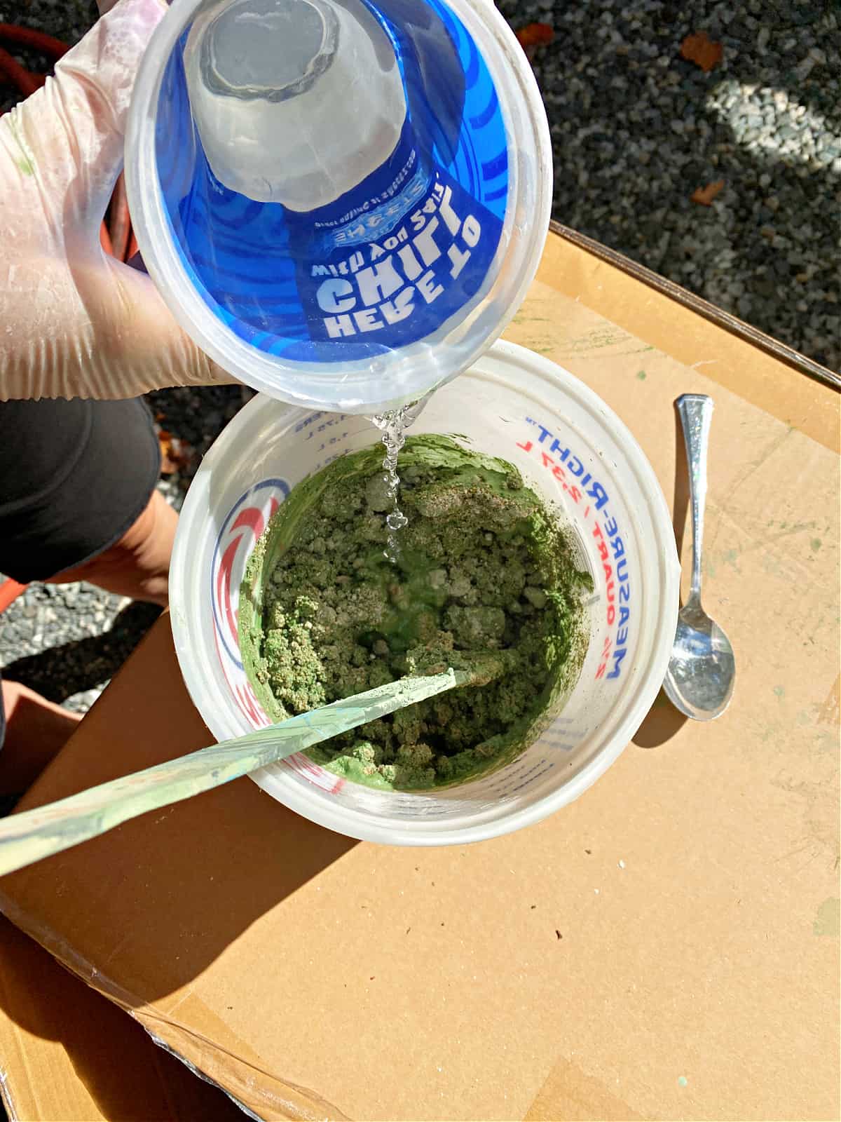 adding water to green tinted concrete mixture