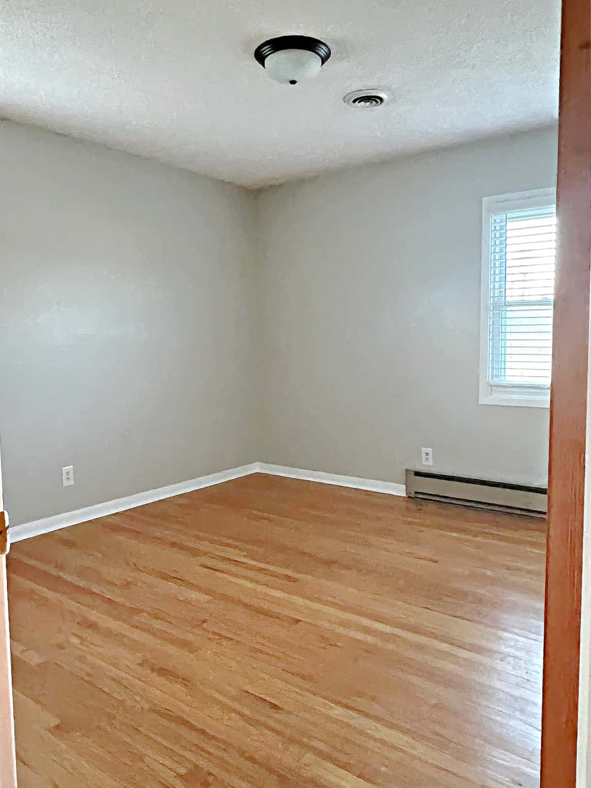 empty master bedroom with window and gray painted walls