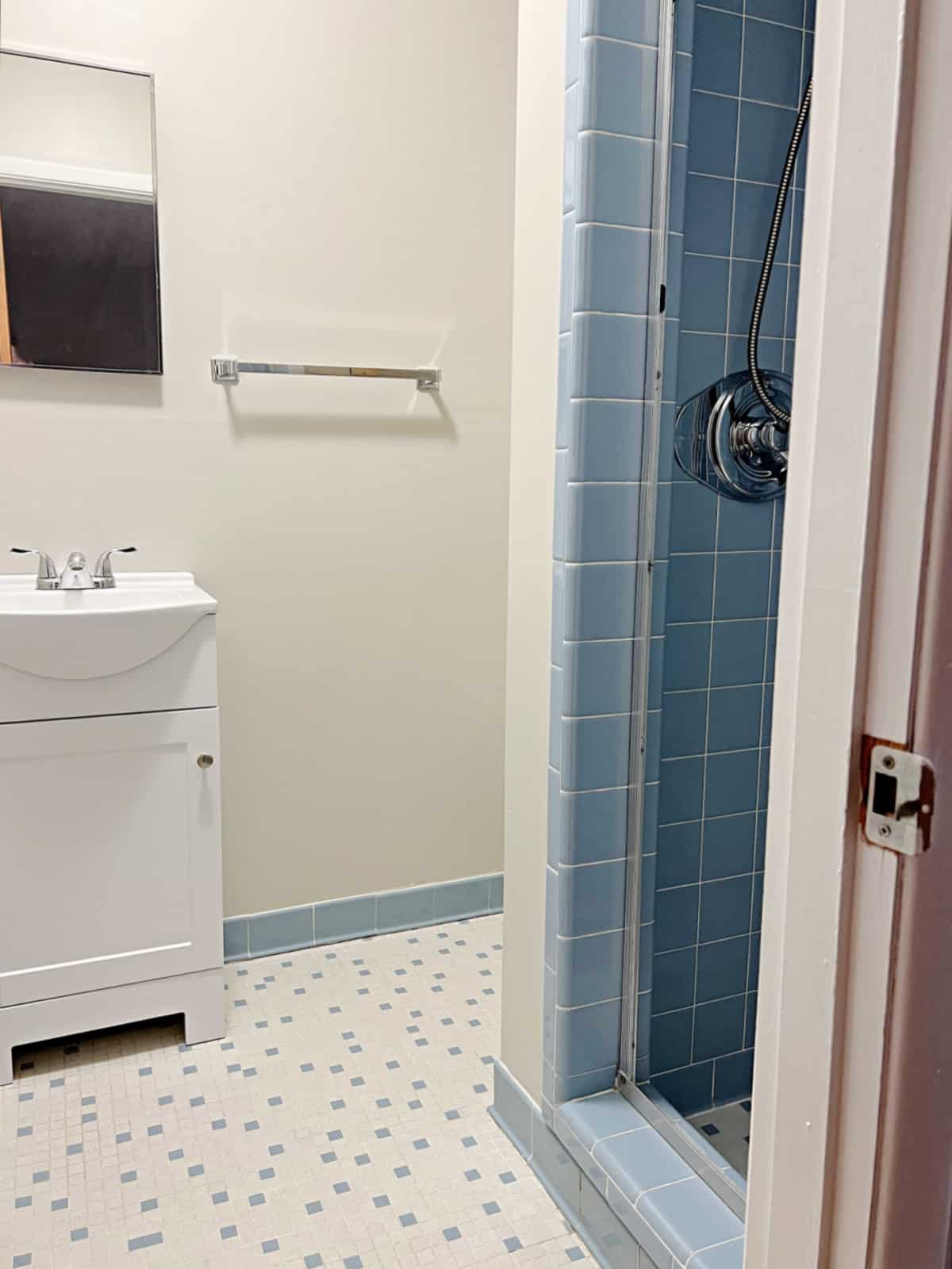 master bedroom with blue tile shower and small vanity