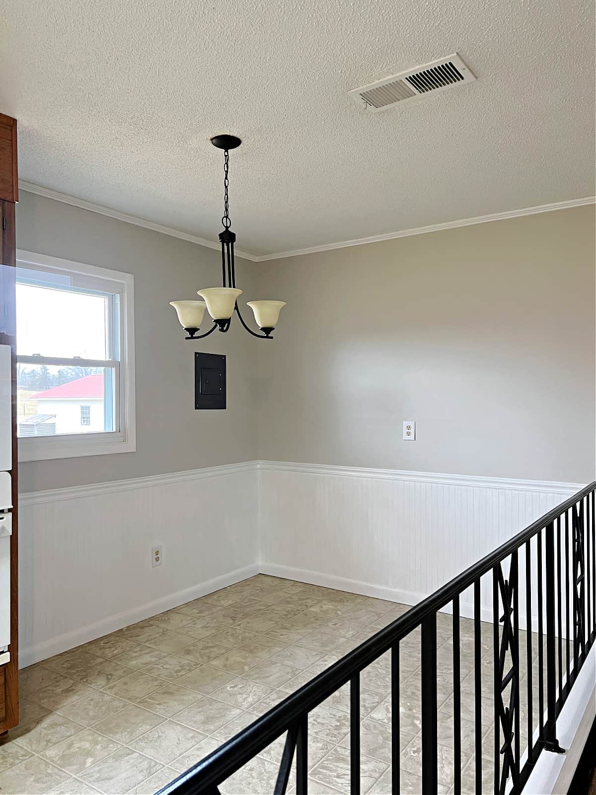 small dining area with pendant light and beadboard on wall