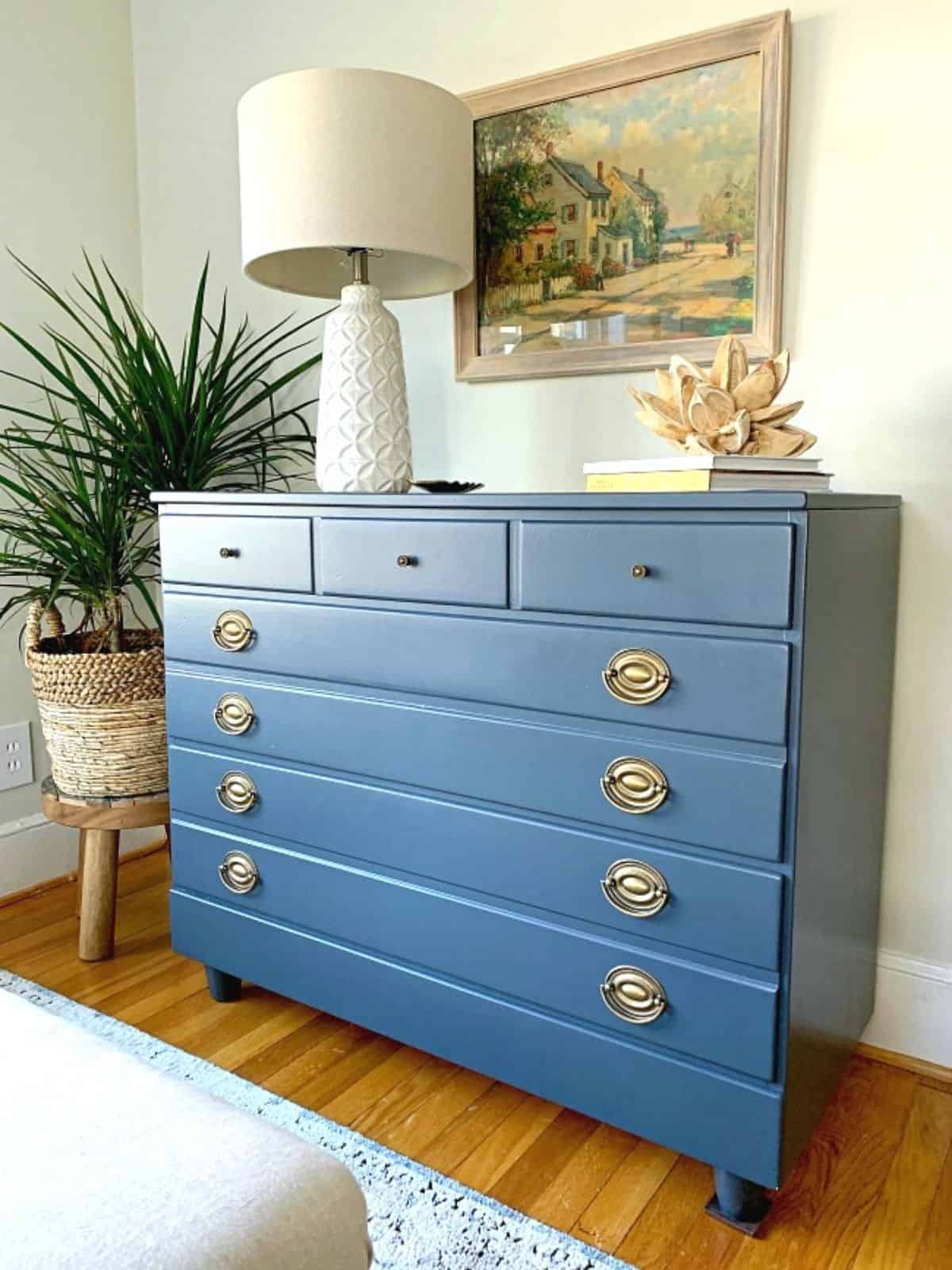GoodWill dresser painted in navy with a white lamp on top