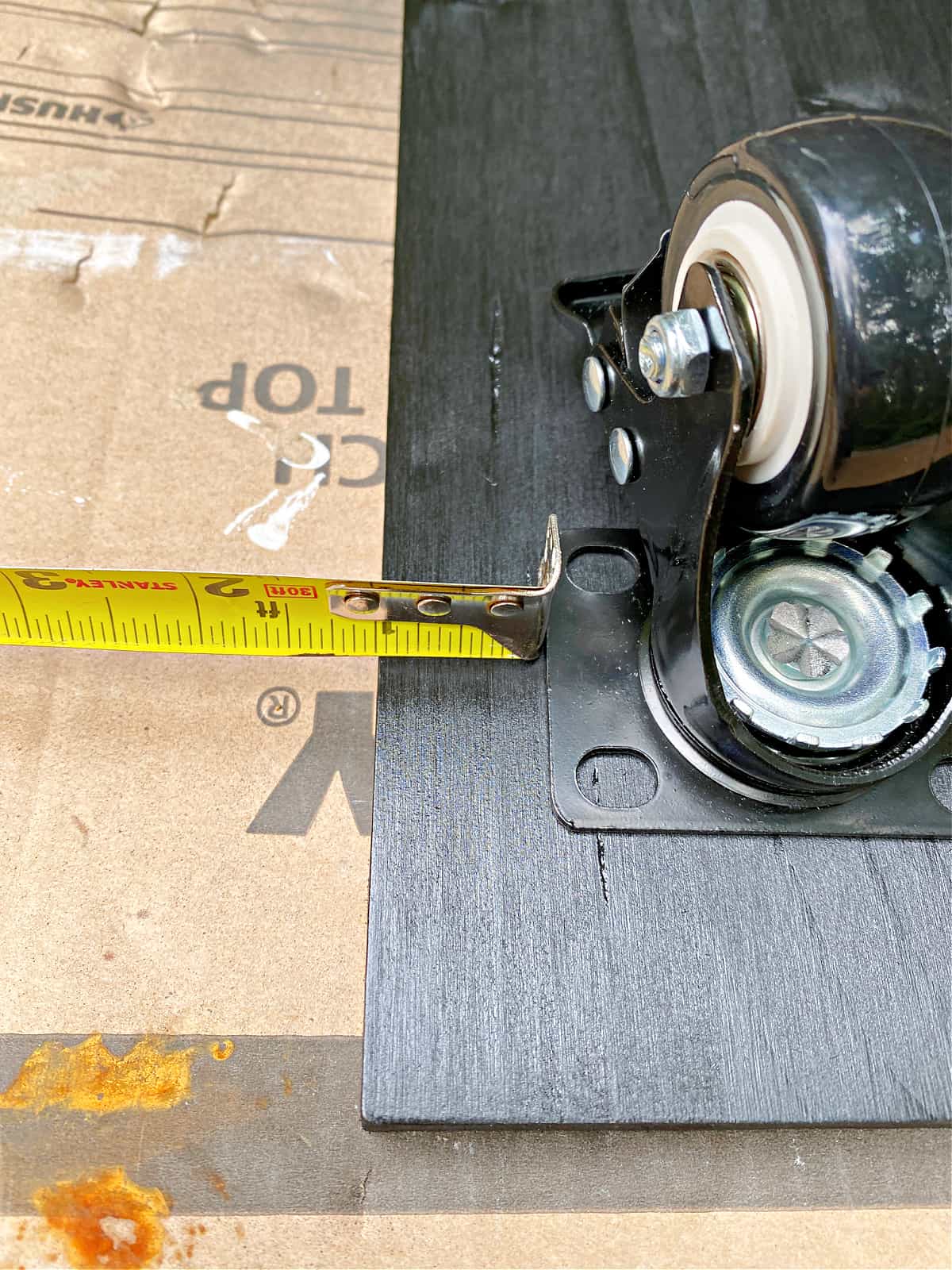 using tape measure to place casters on wood