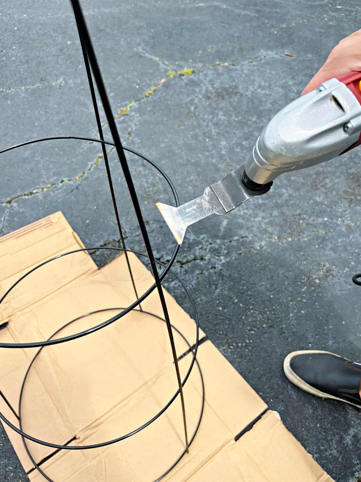 Easy DIY Plant Stand pic using a cutting tool to cut wire legs off of tomato cage