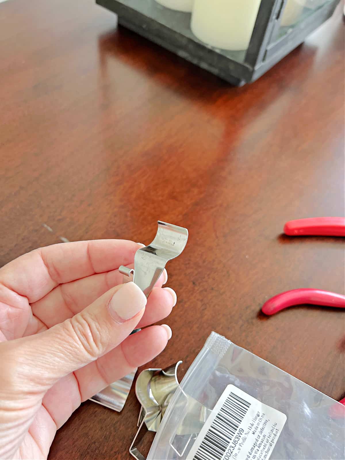 holding a hook to hang picture on vinyl siding