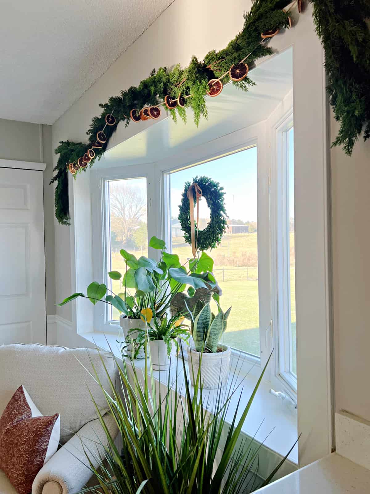 bay window with plants and garland around it