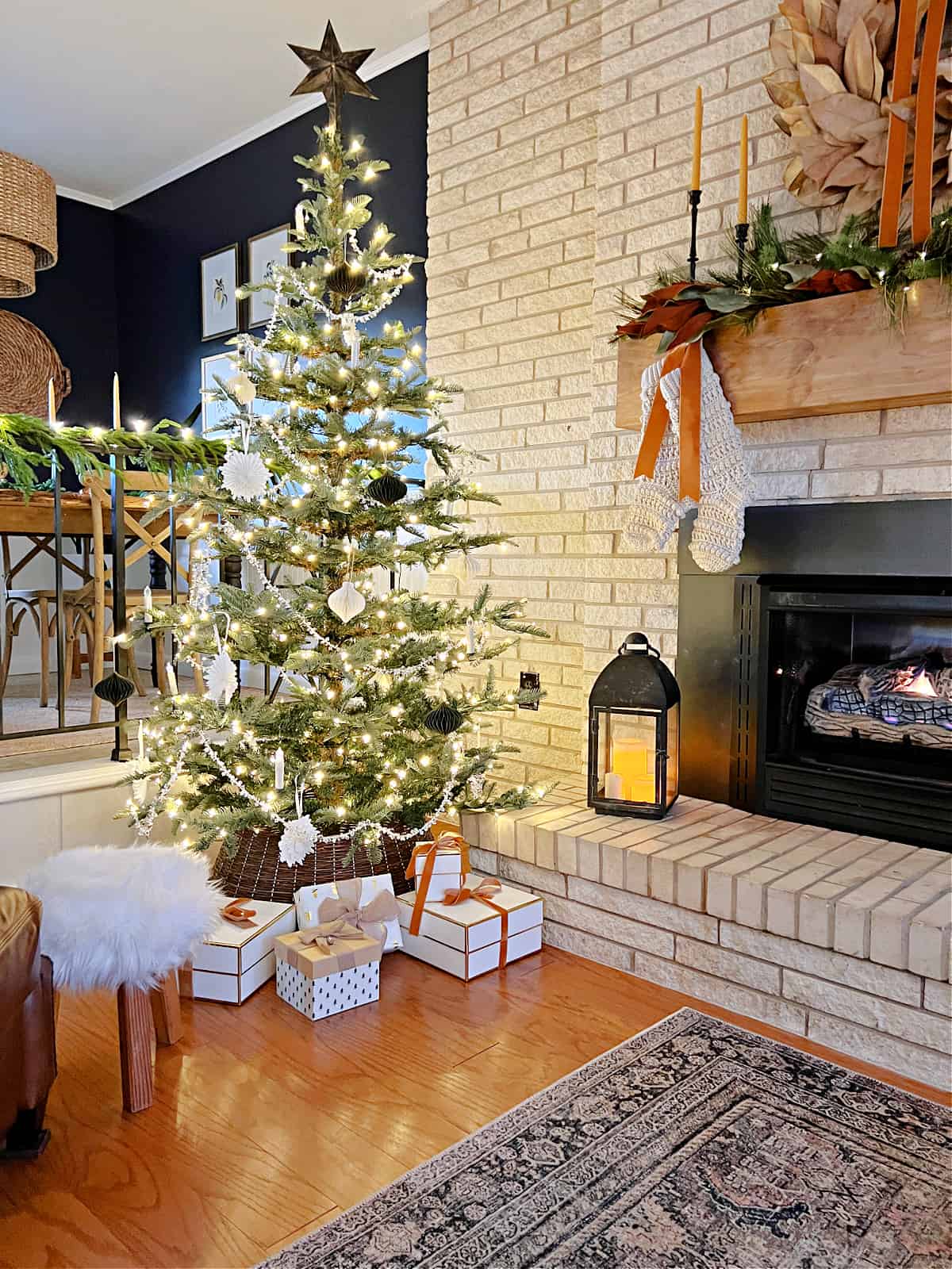 Christmas tree next to a living room fireplace 