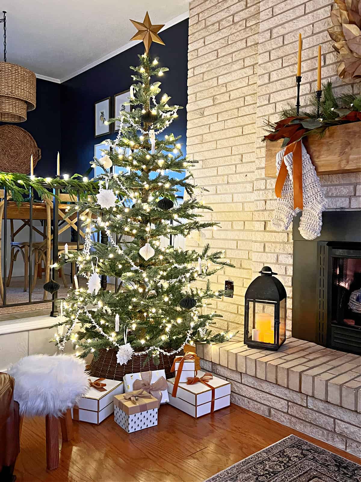 Christmas tree next to a living room fireplace 